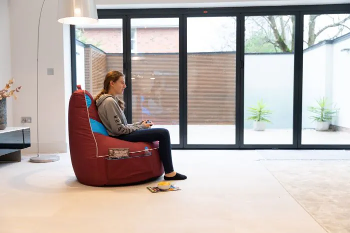 Side Profile of the Girl Sitting on the West Ham United F.C. Gaming Bean bag Chair in the Living Room 
