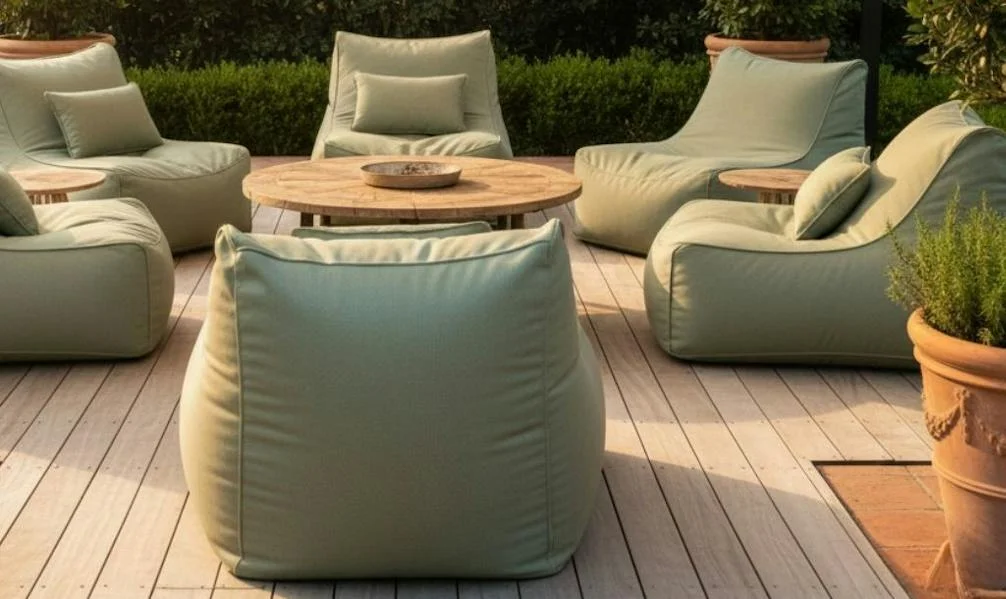 Sage green beanbags around a wooden table under an outdoor awning