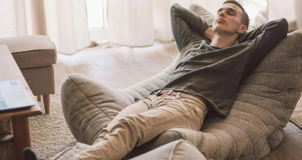 Man reclining on a luxurious taupe colour bean bag 