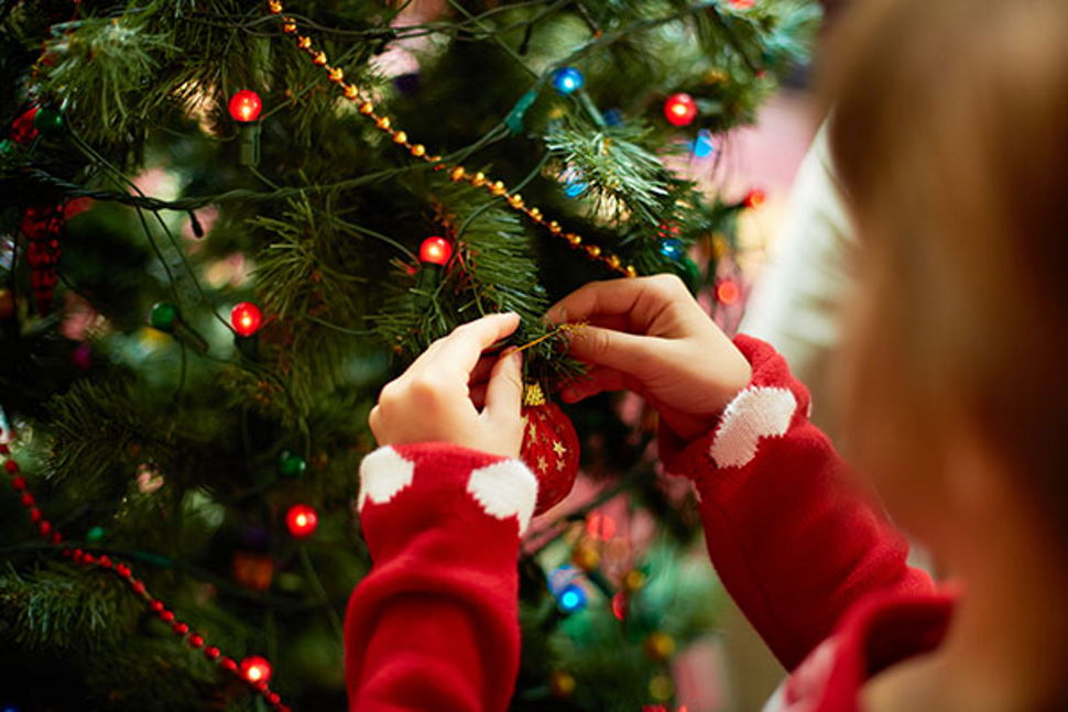 Young girl putting decorations on a Christmas Tree